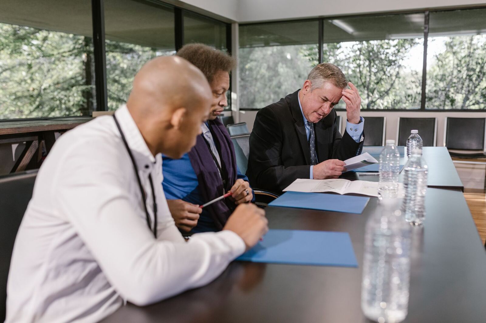 Group of diverse colleagues in a business meeting reviewing documents indoors.