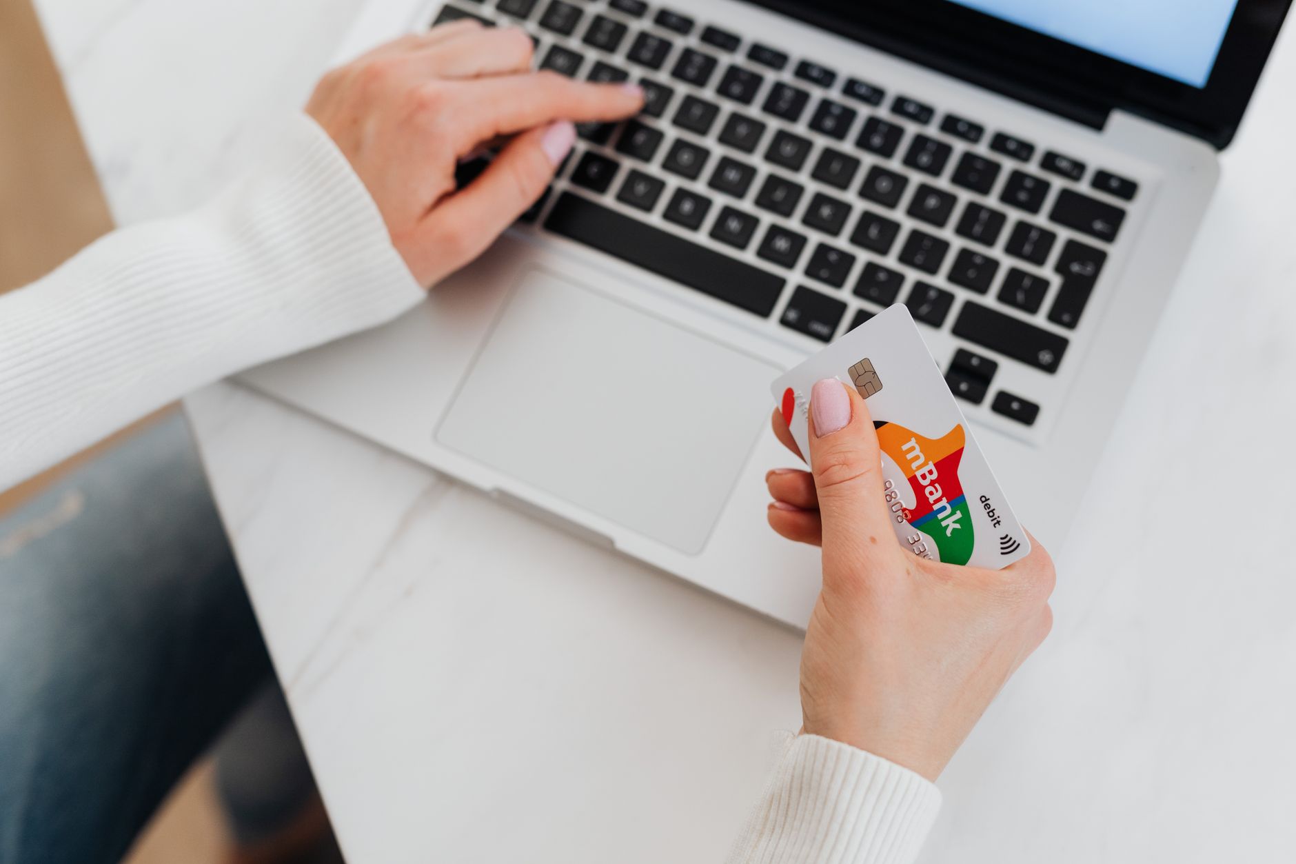 A bank card beside a laptop showing a payment dashboard, illustrating prop firm payouts