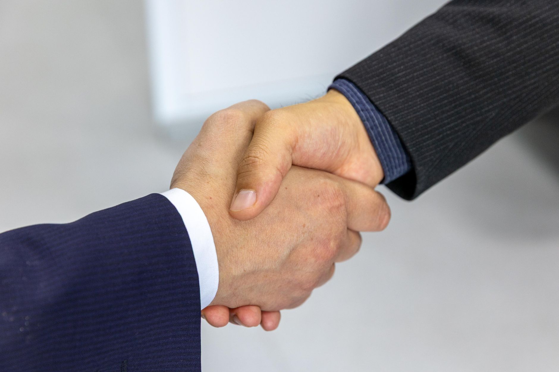 business meeting handshake office, illustrating the questions to ask a prop firm technology provider